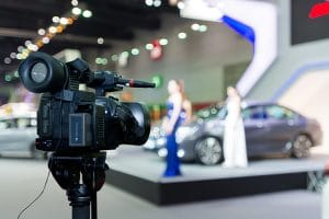 Covering an event on stage with a video camera.